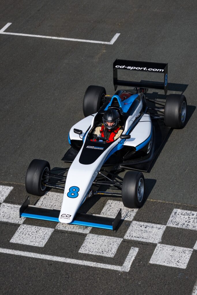 Formule 4 en virage sur circuit asphalte